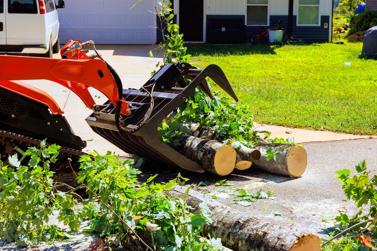 Machinery clearing debris from a driveway